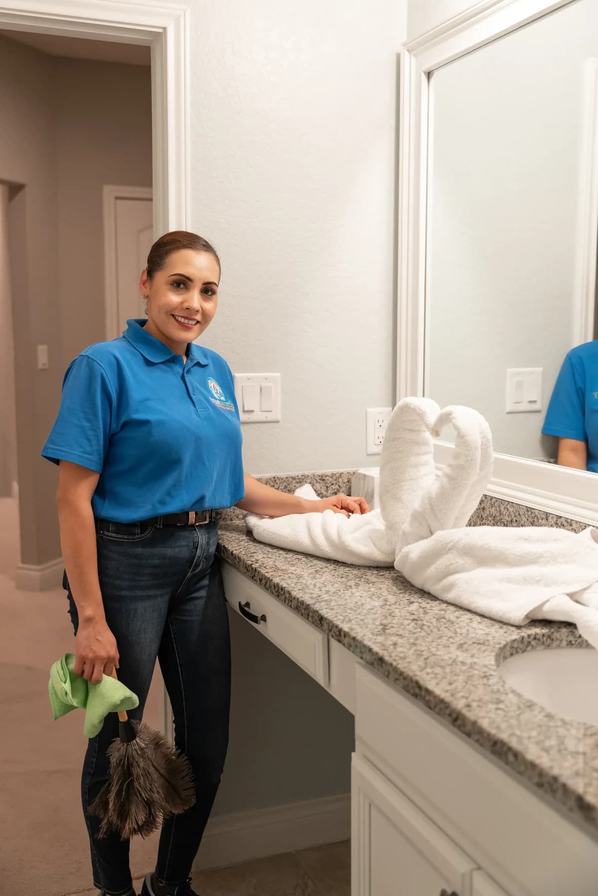 Cleaner finishing a bathroom vanity with folded towels