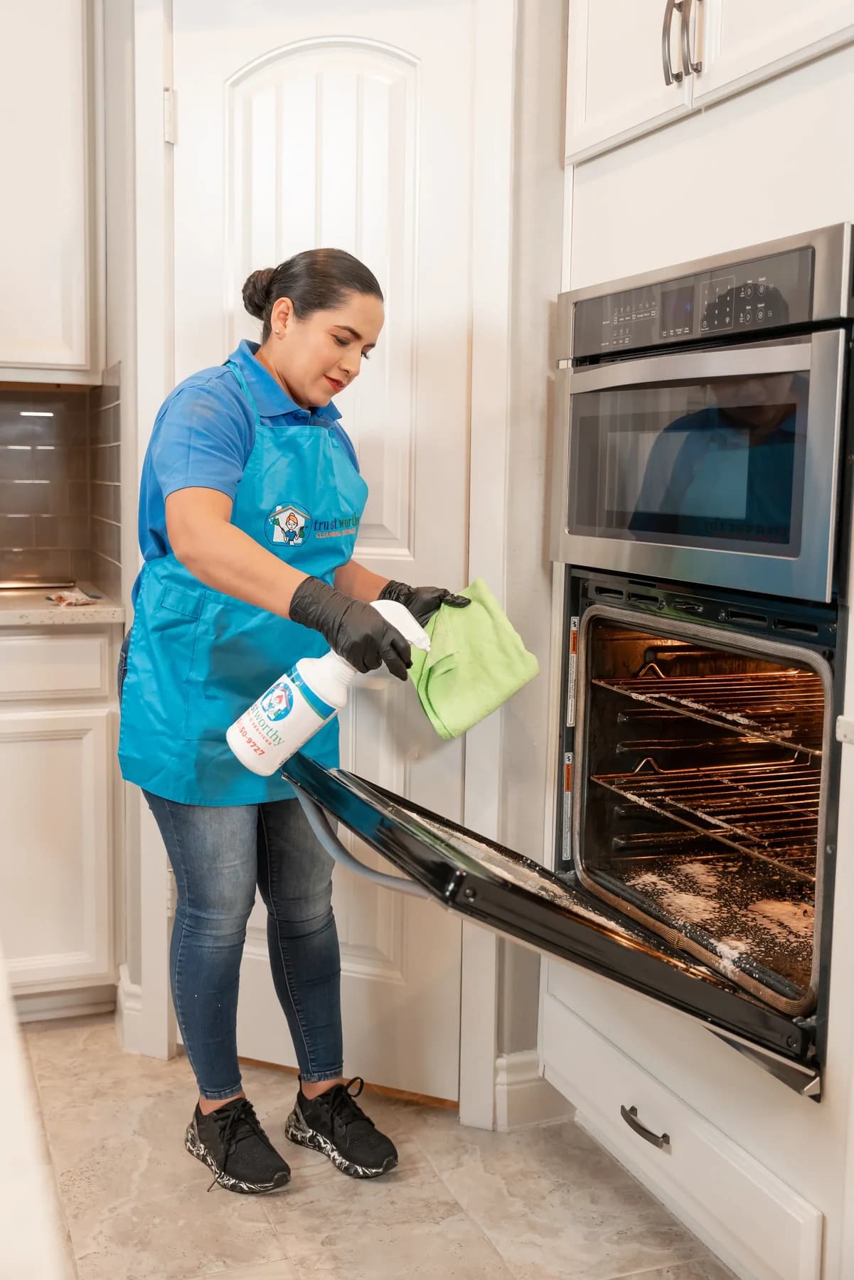 Cleaner scrubbing the inside of an oven during a deep clean