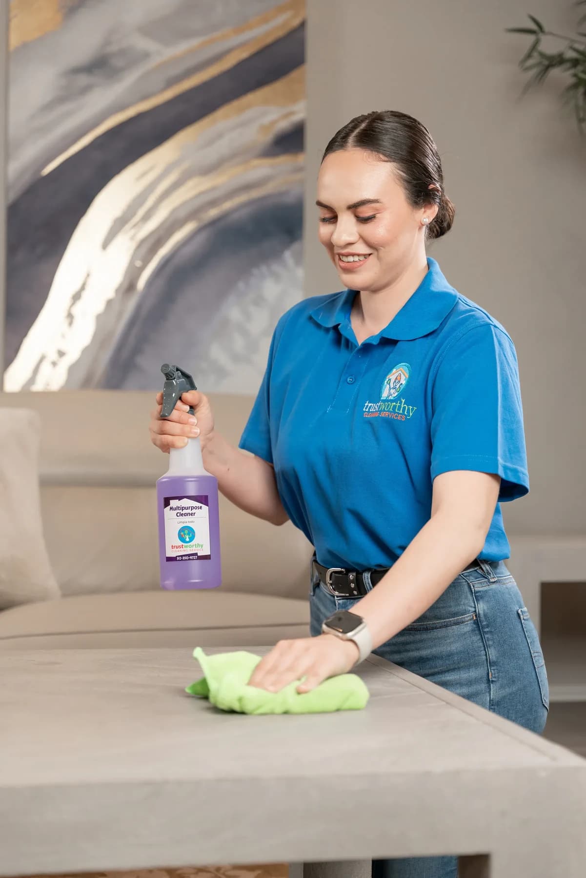 Cleaner disinfecting a table with a pet-safe spray