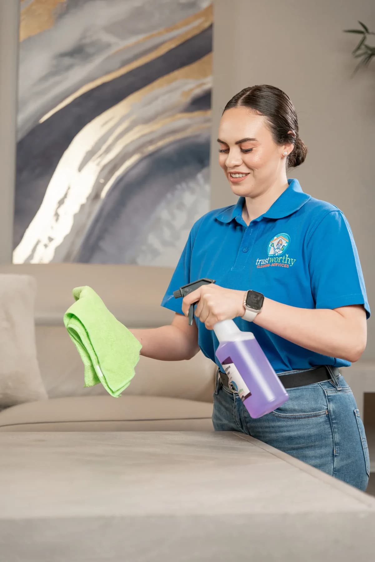 House cleaner dusting a living room table in an Austin home