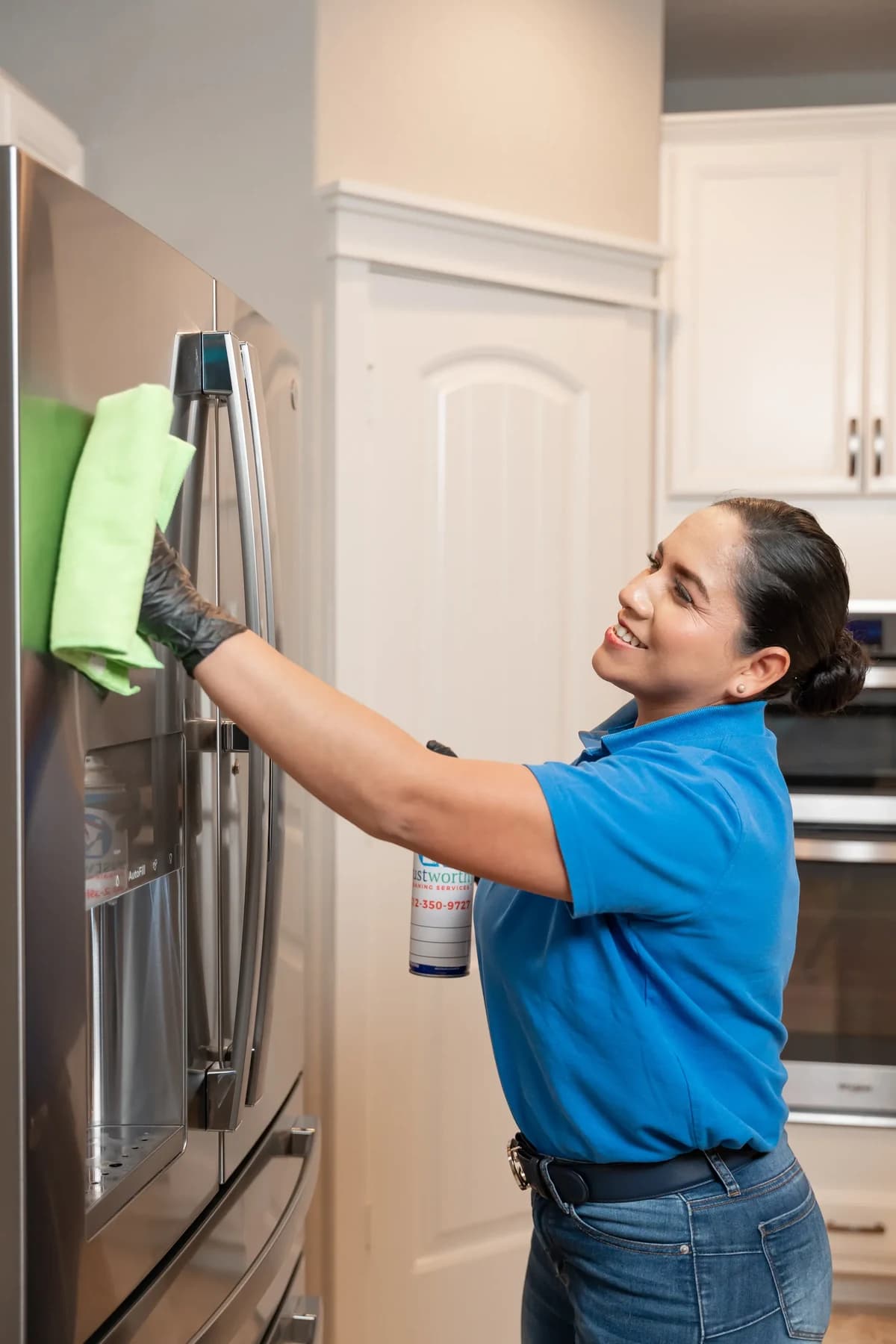 Cleaner polishing a stainless steel refrigerator door