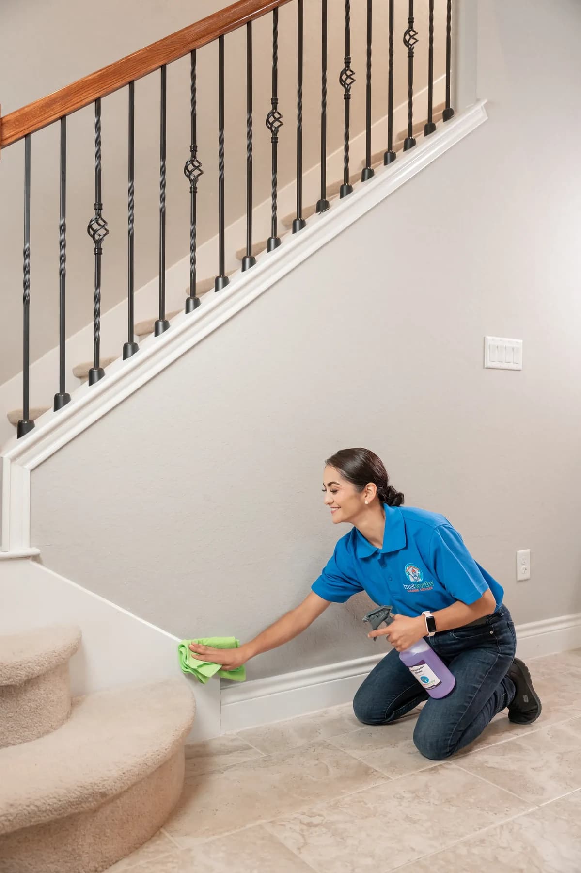 Cleaner wiping stair steps and baseboards by hand