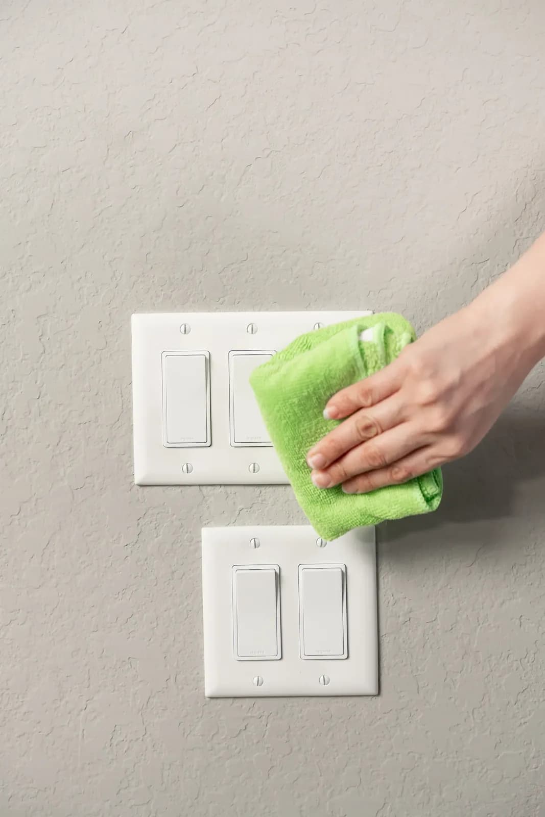 A Trustworthy cleaner disinfecting a light switch, a high-touch surface, in Austin, TX